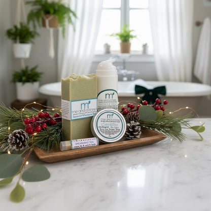 Muscle Relief Winter Wellness Set with natural soap, healing salve, lip balm, and lotion displayed in a holiday botanical spa scene